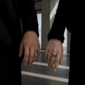 design rings on male and female hands in modern Scandinavian architecture setting